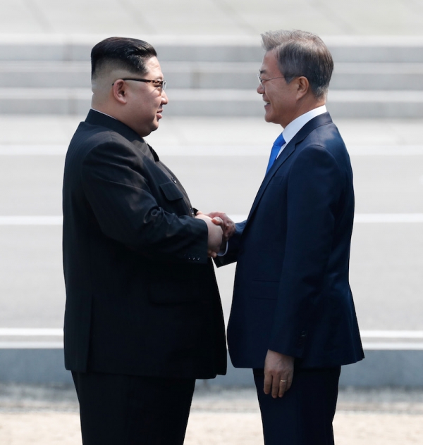 4月27日、板門店の軍事境界線上で握手する韓国の文在寅大統領と北朝鮮の金正恩国務委員長。写真は板門店合同取材団。