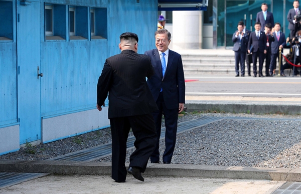 4月27日、板門店の軍事境界線上で握手する韓国の文在寅大統領と北朝鮮の金正恩国務委員長。写真は板門店合同取材団。