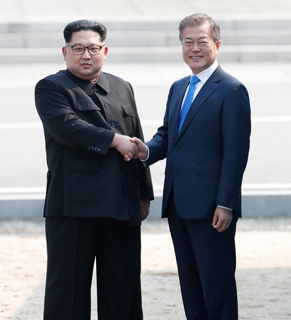 4月27日、板門店の軍事境界線上で握手する韓国の文在寅大統領と北朝鮮の金正恩国務委員長。写真は板門店合同取材団。