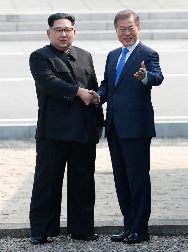 4月27日、板門店の軍事境界線上で握手する韓国の文在寅大統領と北朝鮮の金正恩国務委員長。写真は板門店合同取材団。