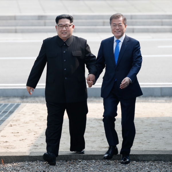 4月27日、板門店の軍事境界線上で握手する韓国の文在寅大統領と北朝鮮の金正恩国務委員長。写真は板門店合同取材団。